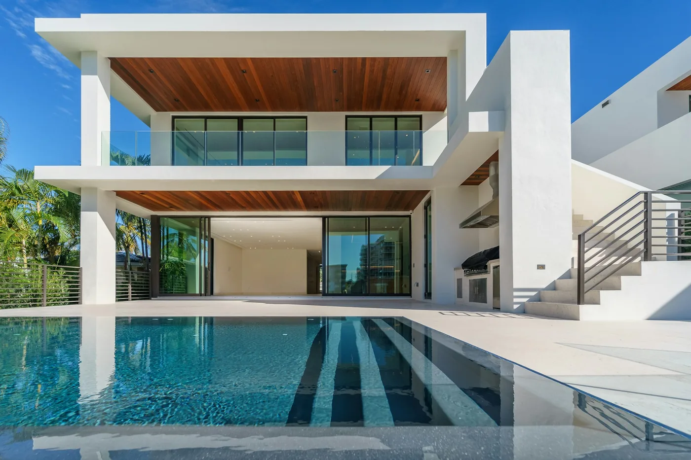 Modern Florida home with a turquoise pool and palm trees